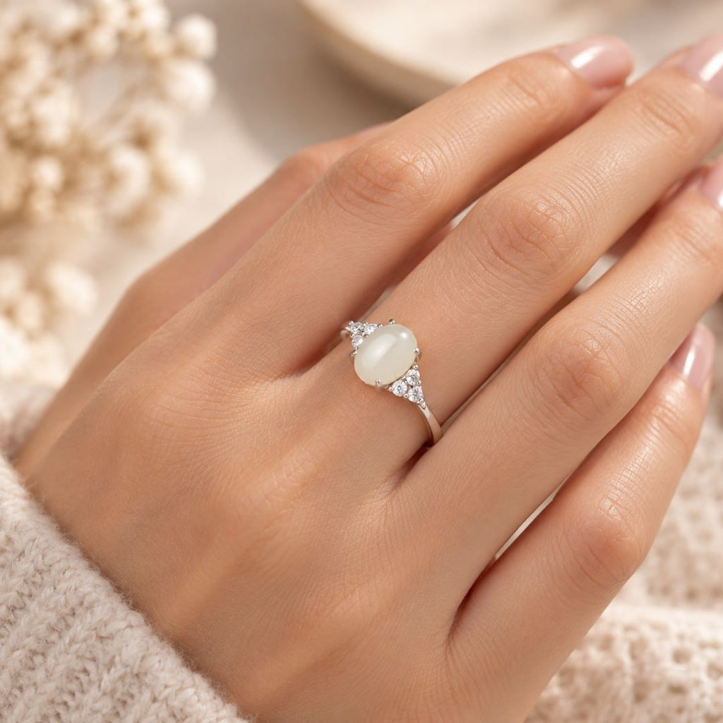 Elaris Moonstone Ring worn on a woman's hand with an oval white moonstone and sparkling accents