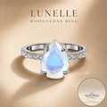 Lunelle pear-shaped moonstone ring showcased against a warm champagne-beige background with soft lighting and refined shadow