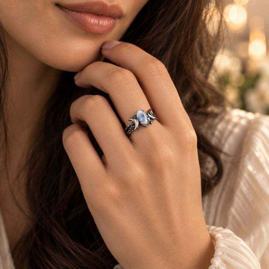 Veyra moonstone ring worn on a woman's hand in an elegant warm-toned lifestyle setting